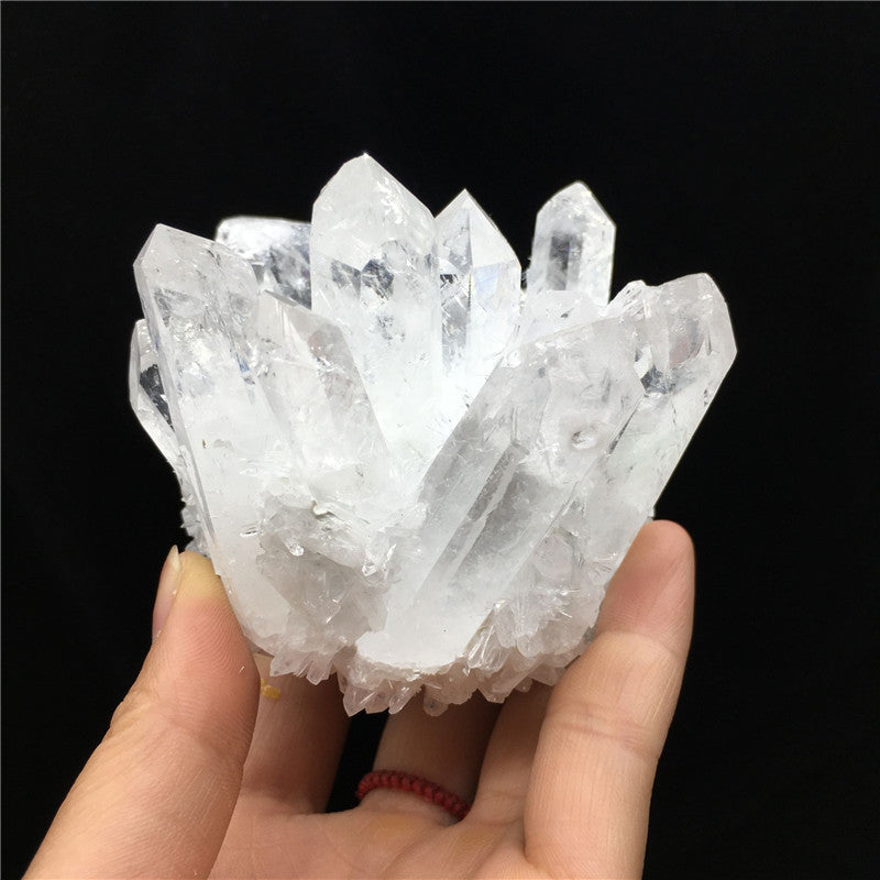 hand holding a clear quartz cluster